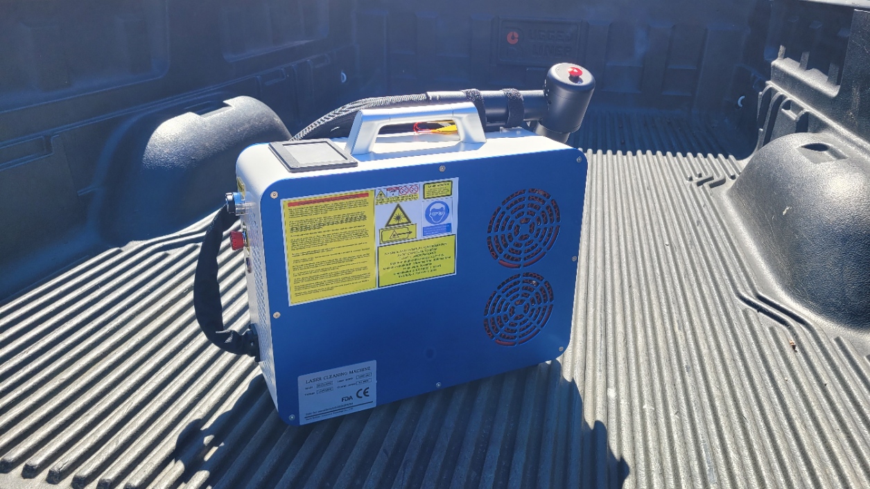 Portable blue laser cleaner sitting in the bed of the Tech Bravo truck